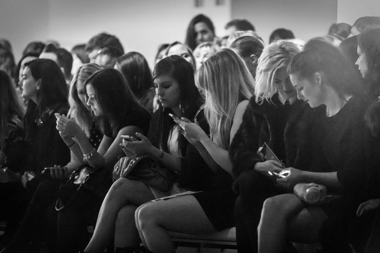 London Fashion Week audience checking cellphones mobiles