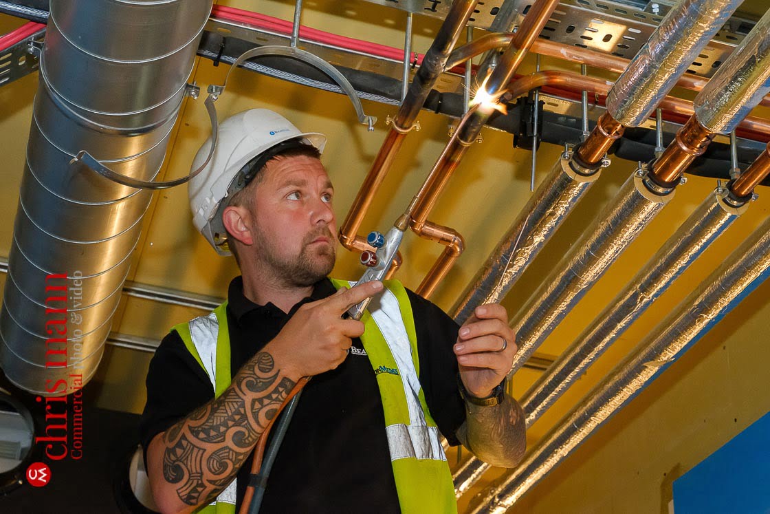 worker brazes joints in copper piping for Royal Surrey Hospital ward construction